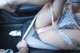 A woman is sitting in the back seat of a car.