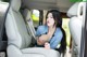 A woman sitting in the back seat of a car.