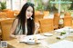 A woman sitting at a table with a plate of food.