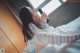 A woman sitting on a bed holding a cell phone.