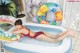 A woman in a red bathing suit laying in an inflatable pool.