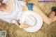 A woman laying on a pile of hay with a cowboy hat.