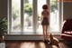 A girl standing in front of a window looking out at a dog.