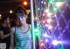 A woman sticking out her tongue in front of a string of lights.