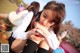 A young girl sitting on the ground looking at her cell phone.