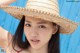 A woman in a straw hat posing for a picture.